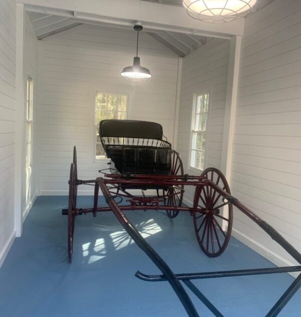 Horse-drawn carriage in a white room.